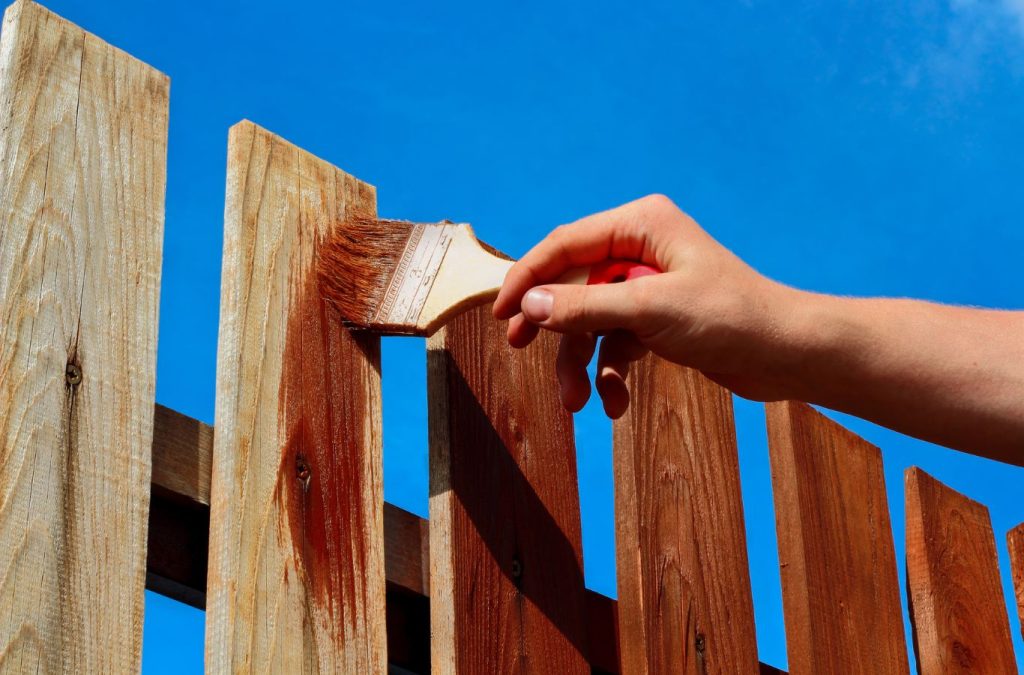 A Grandview Painting team member delivering fence painting in Dubuque, IA, demonstrating the benefits of using a local professional for this essential service.