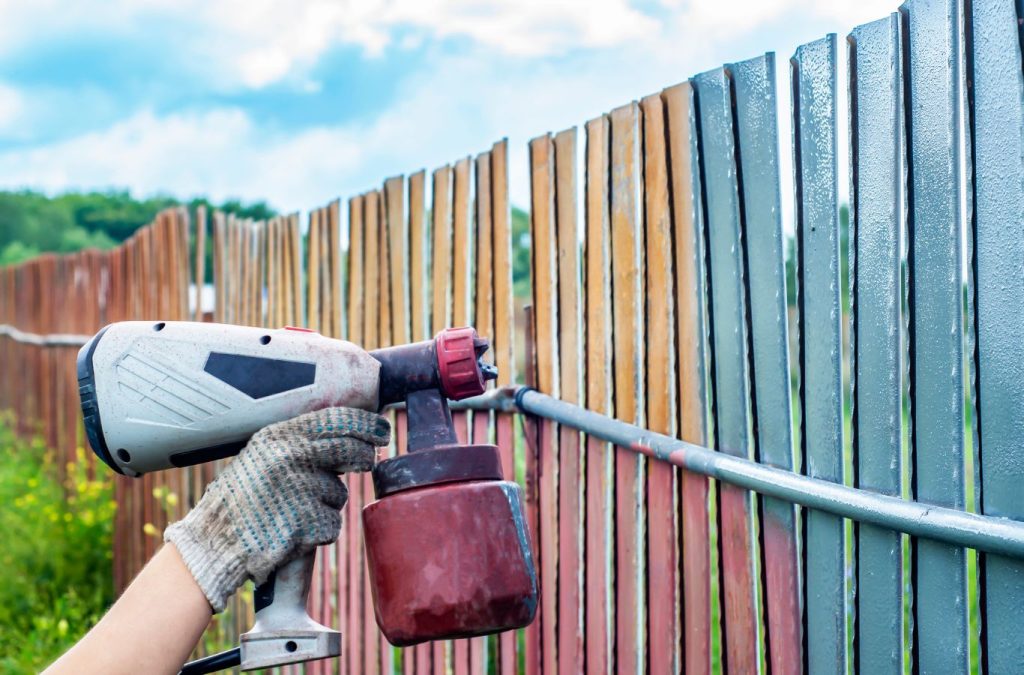 A Grandview Painting expert providing fence painting in Dubuque, IA, showing why we are the best choice. Fence painting near me.