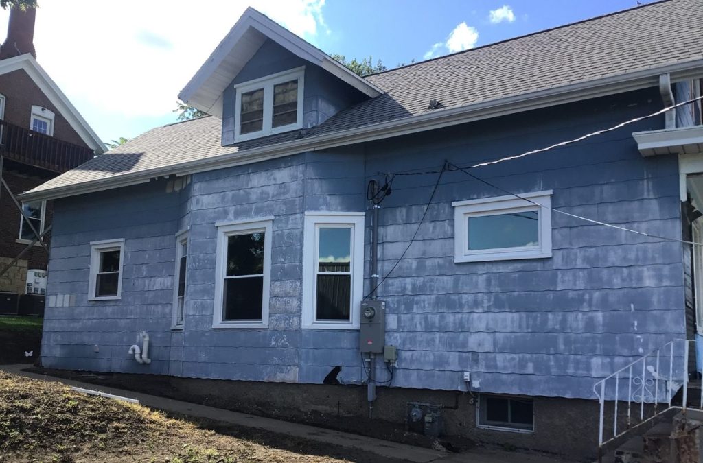 A Grandview Painting team member skillfully applying exterior paint in Cuba City, WI, showcasing the advantages of hiring a local expert.