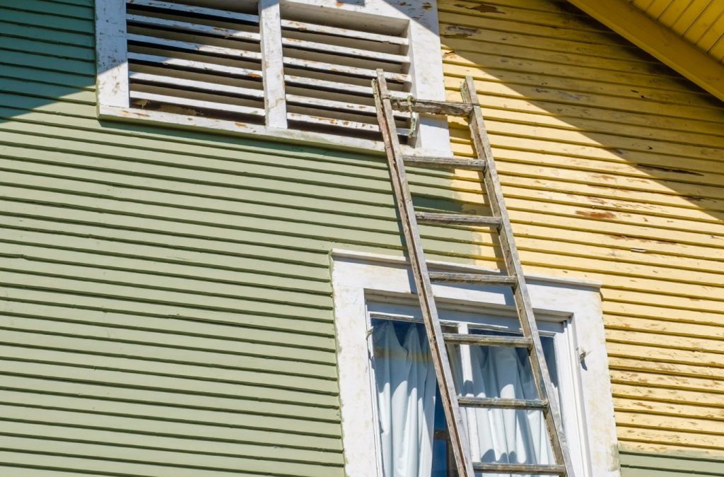 A Grandview Painting professional expertly applying exterior paint in Hazel Green, WI, using top-quality tools for a flawless finish.